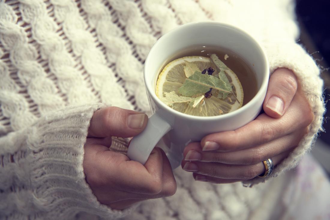 Person holding mug of herbal tea