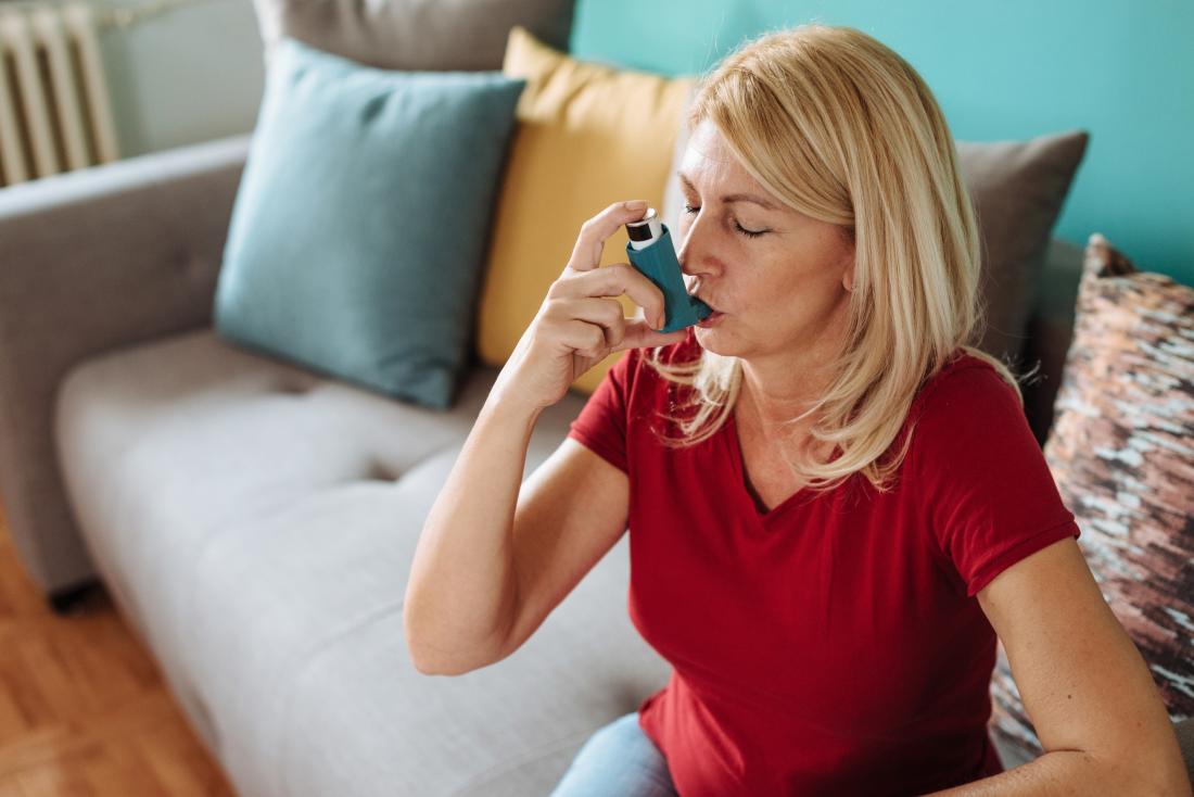 woman using an asthma inhaler