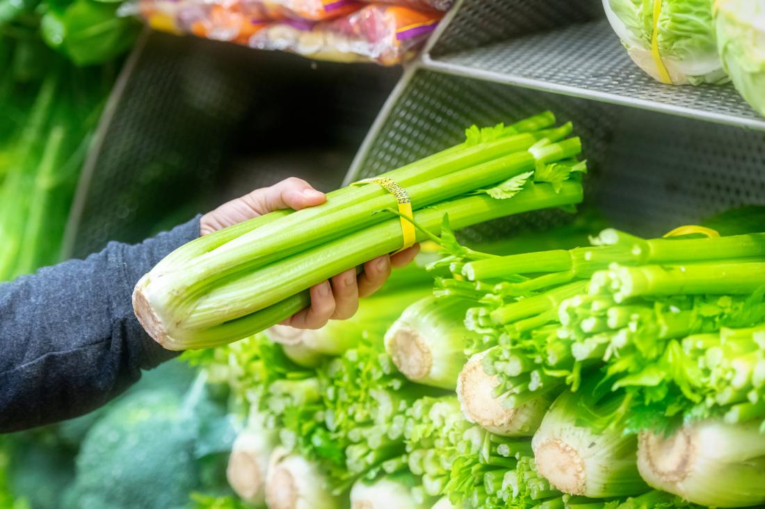 hand holding a bunch of celery