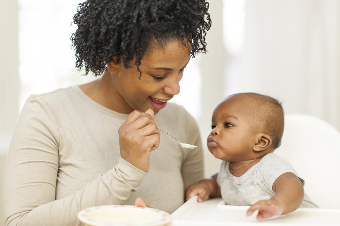 mother feeding baby solid food