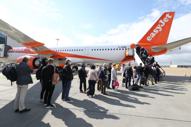 Passengers prepare to board an easyJet flight to Faro, Portugal, at Gatwick Airport on