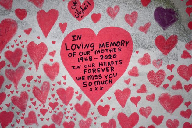 Messages are pictured on hearts painted on the National Covid Memorial Wall, at the embankment on the...