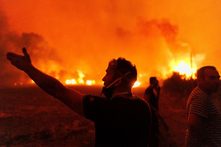 People react as they try to extinguish a wildfire in Avantas village, near Alexandroupolis town, in the northeastern Evros region of Greece on Aug. 21, 2023.