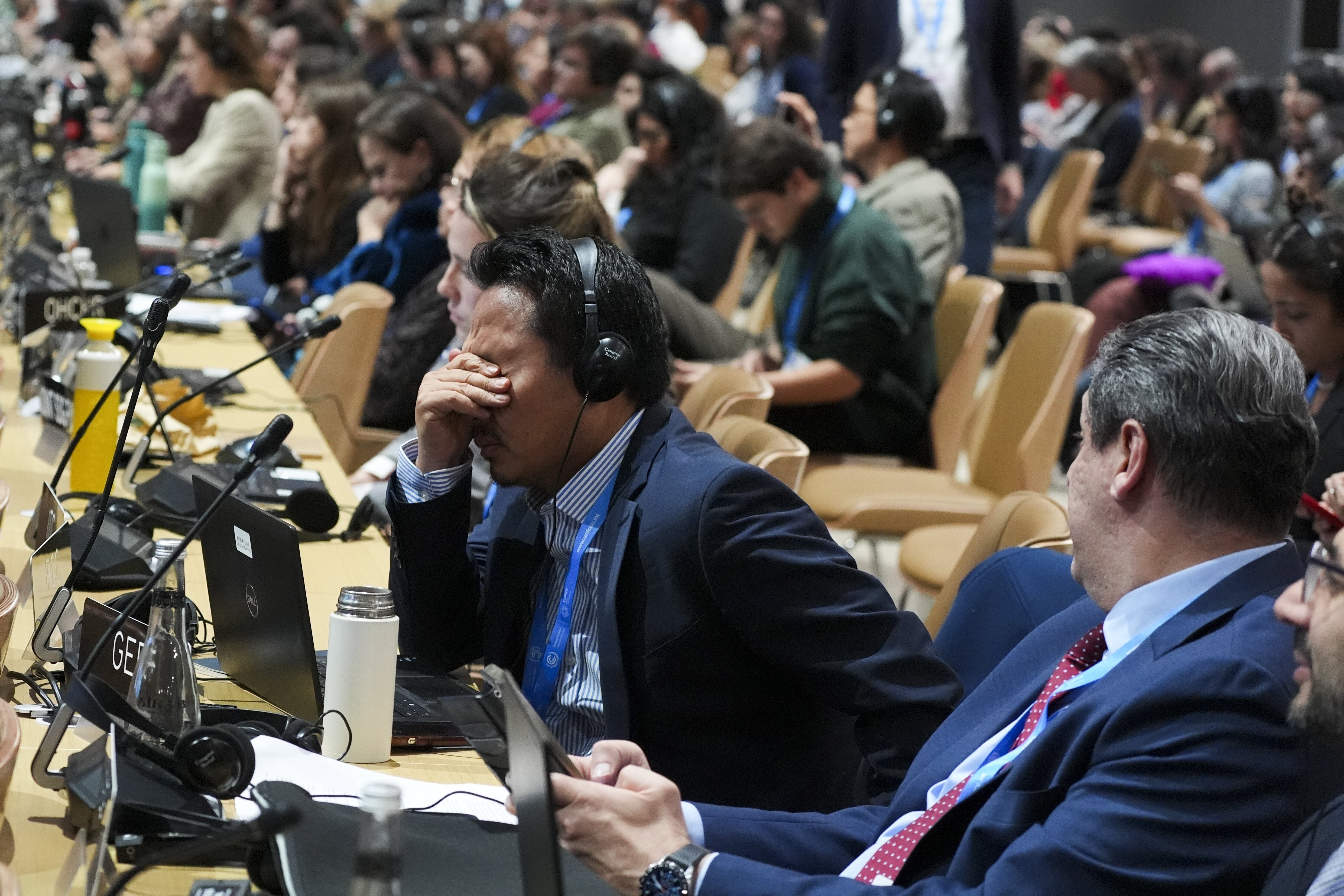 An attendee reacts during a closing plenary session at the COP29 U.N. Climate Summit, Sunday, Nov. 24, 2024, in Baku, Azerbaijan. (AP Photo/Joshua A. Bickel)