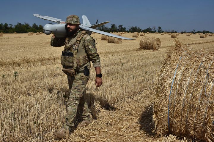 A soldier of Ukraine's National Guard 15th Brigade carries a reconnaissance drone Leleka on a wheat field near the front line in Zaporizhzhia region in Ukraine in July. 