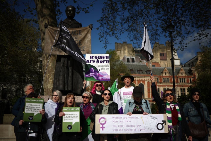 Activists sing as they hold placards including "Women are born, not some bloke with a form" and "Women are women, men are men, you can't change sex with the stroke of a pen" during a protest in Parliament Square across the Supreme Court in London on April 16.